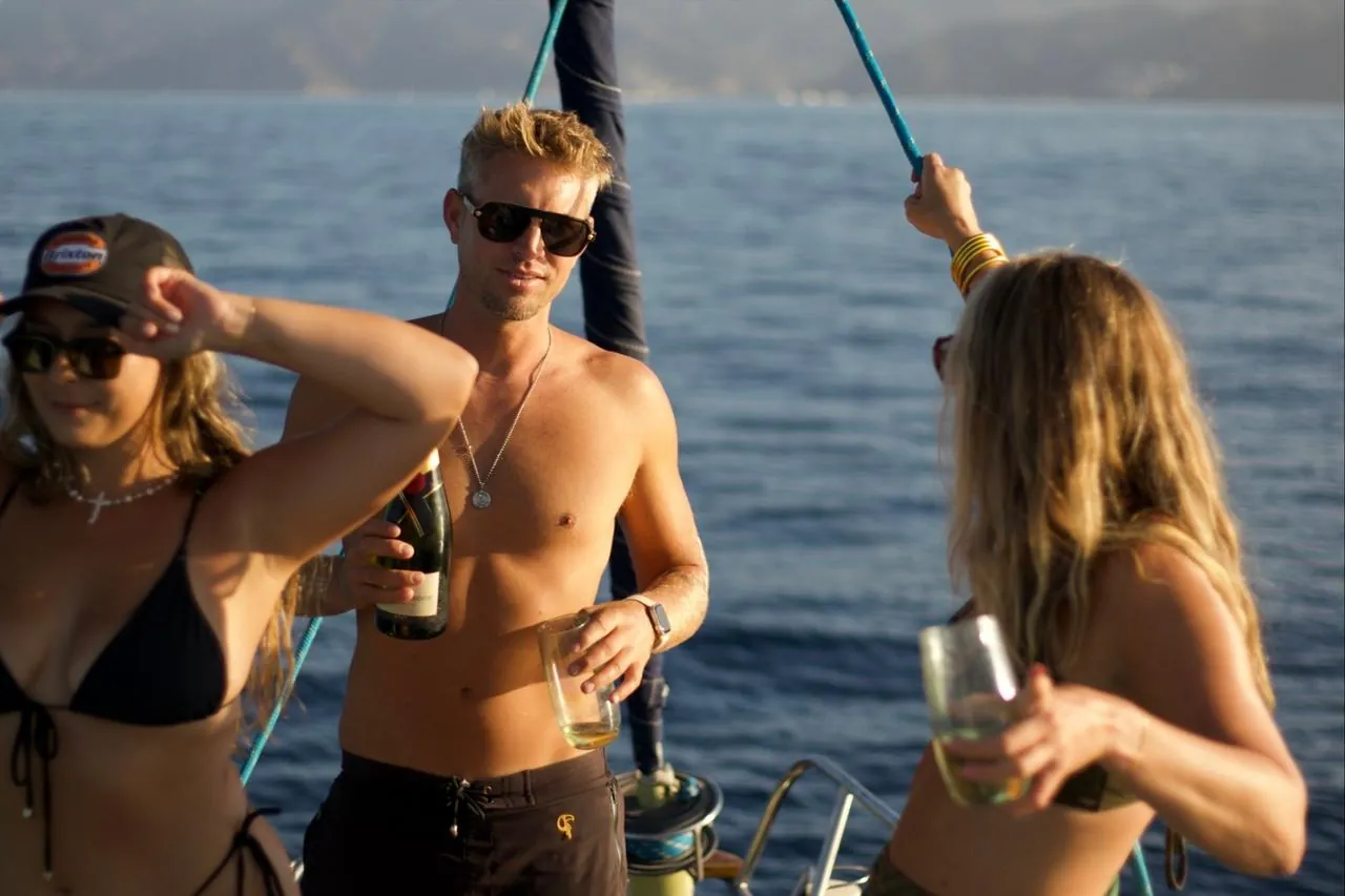 Guests with drinks on the deck of a private yacht