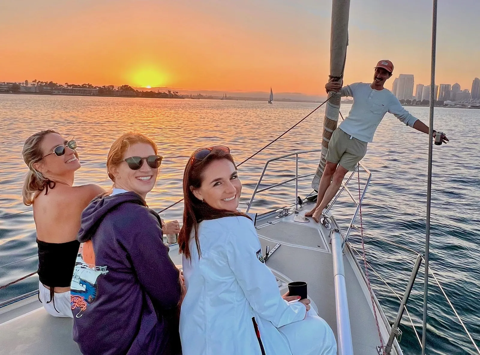 Guests on a small sailboat at sunset on San Diego Bay