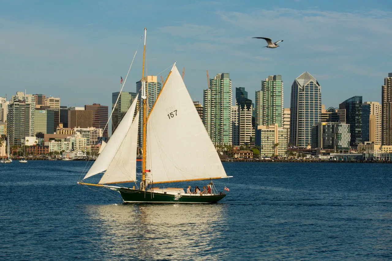 The gaff-rigged sloop Liberty under sail in front of the San Diego skyline